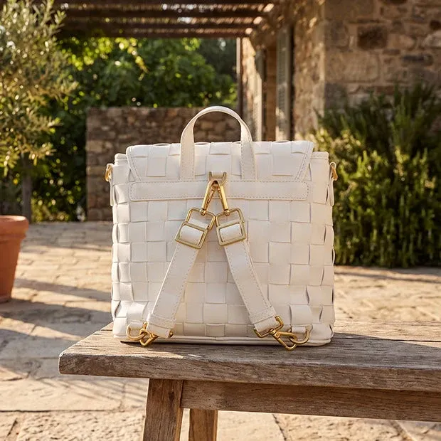 Woven white leather backpack on a wooden bench